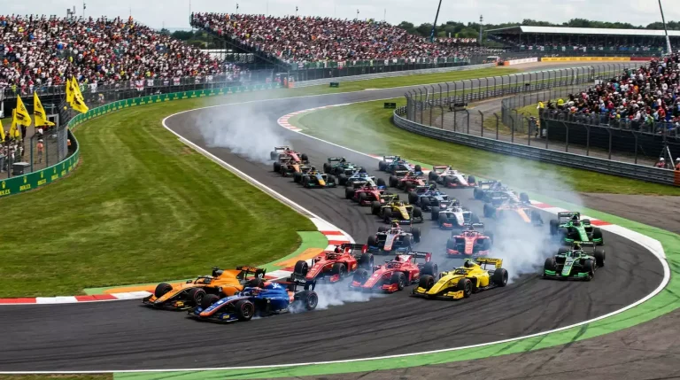 Salida de carrera Sprint de Formula 1 con monoplazas agrupados en la primera curva del circuito